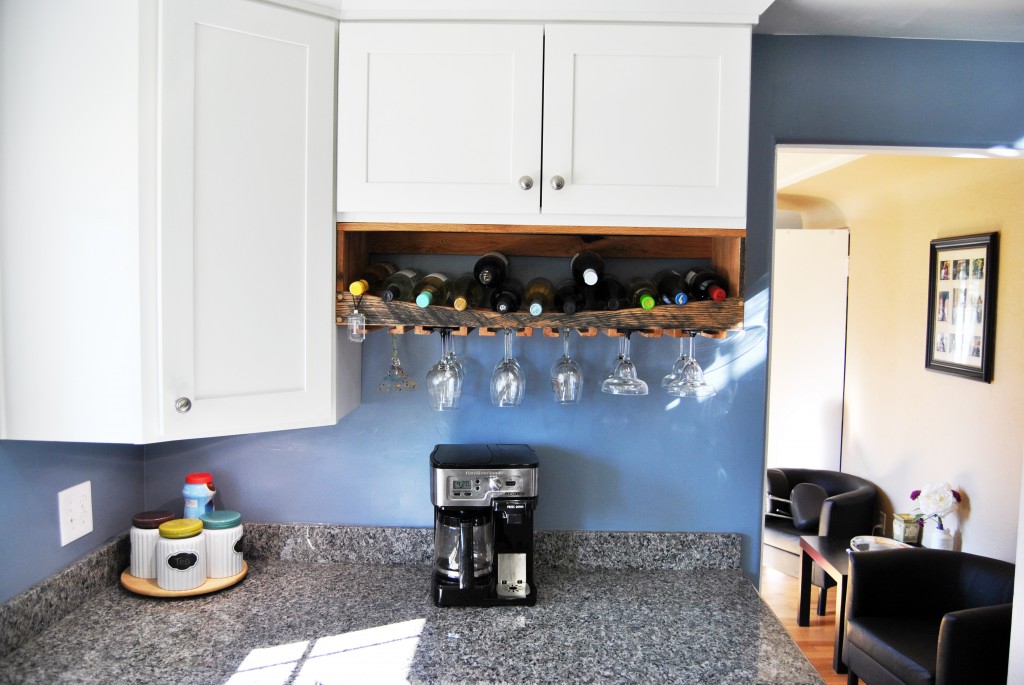 remodeled kitchen with custom oak wine rack, blue walls, granite countertops, white cupboards. Undercabinet lighting. | www.bexbernard.com
