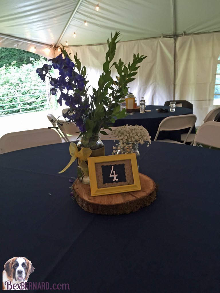 Flower table centerpieces at a rustic nautical wedding in Pacific Northwest with anchor decorations and hay bales. | bexbernard.com