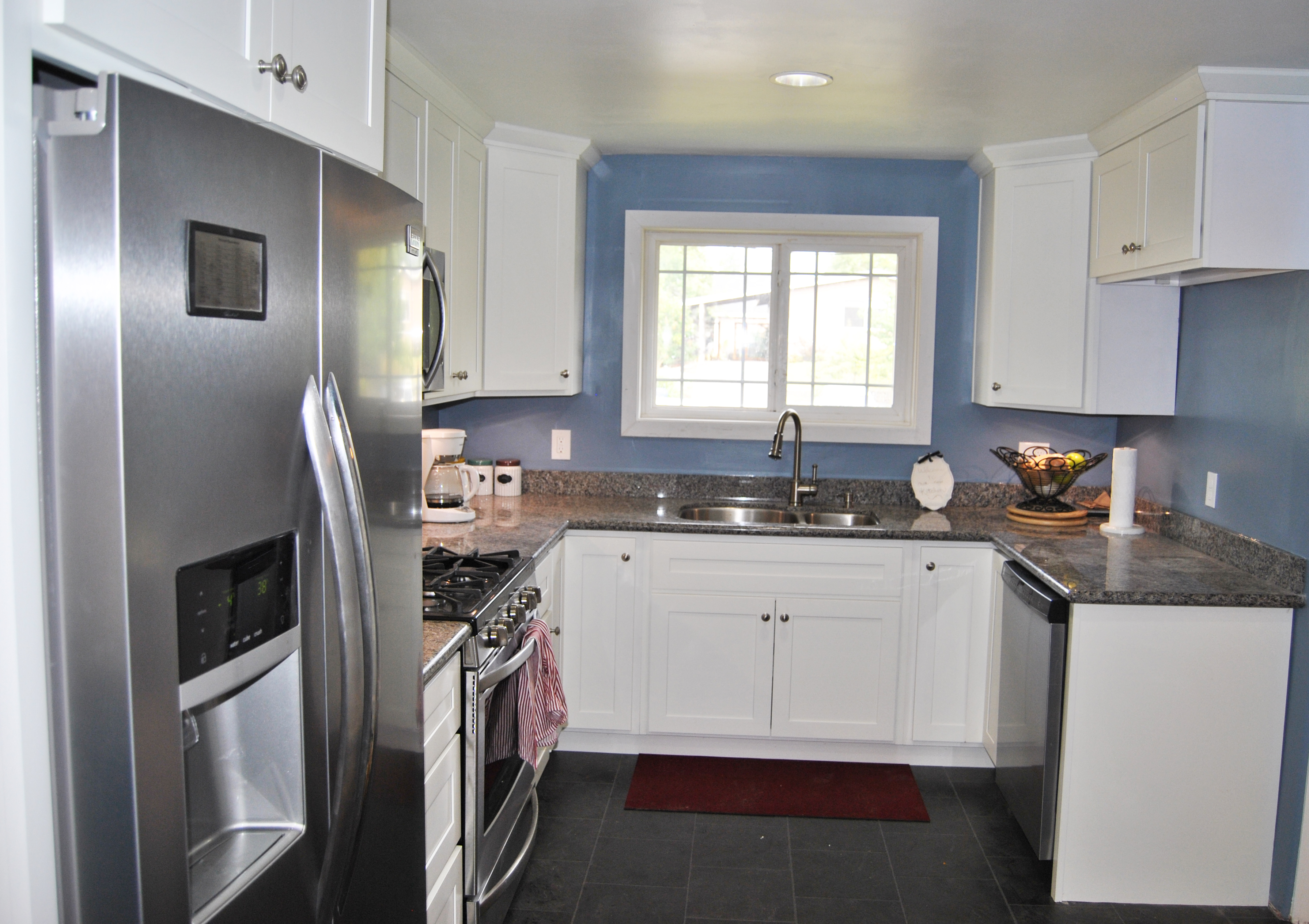 remodeled kitchen stainless steel fridge sink window. white cabinets, gray floor. home improvement. renovation. house reno. | bexbernard.com